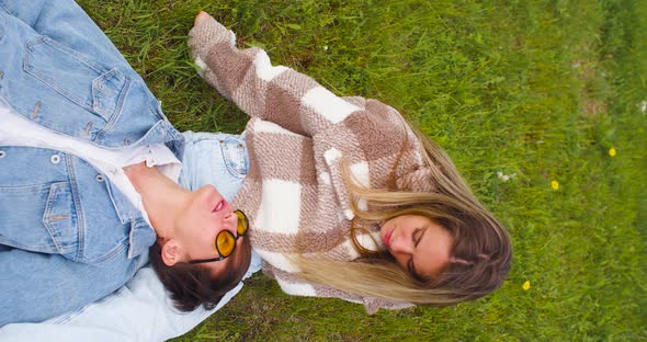 Two Lesbians Enjoy Each Other Lying on the Grass in the Park