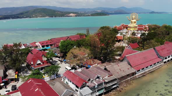 Island with Buddhist Temple and Many Houses. Aerial View of Island with Buddhist Temple with Statue