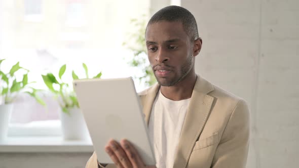 Portrait of African Man Celebrating on Tablet in Office