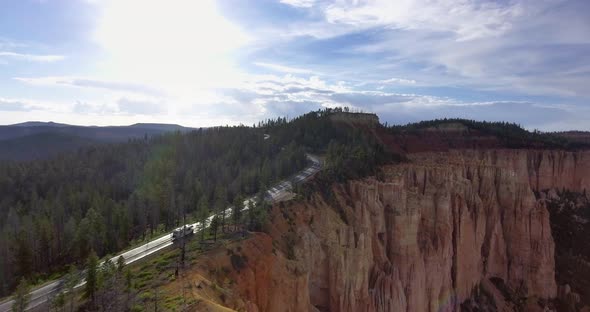 Drone shoots a video on a sunny day a white car on the highway in Zion National Park, Utah, USA