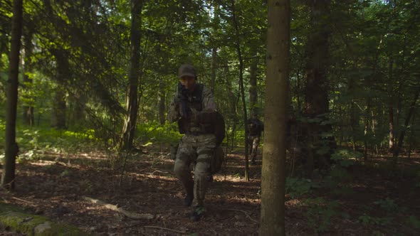 Reconnaissance Squad Wading Through Dense Forest Approaching Pathway