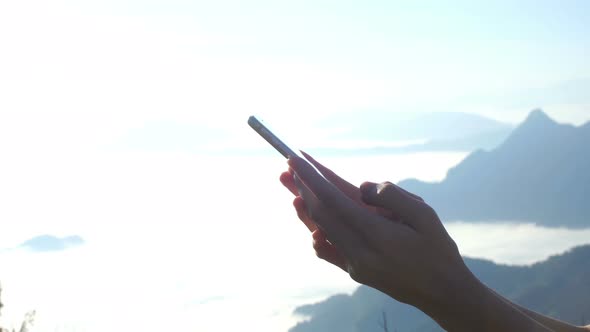 Typing Text Message On Smartphone In Mountain