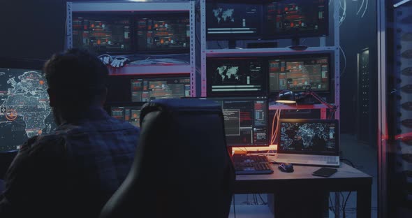 Hacker Watching Multiple Monitors