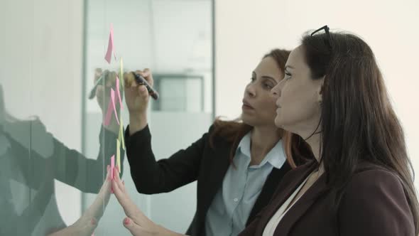 Businesswomen Wearing Suits, Writing Messages on Sticky Notes