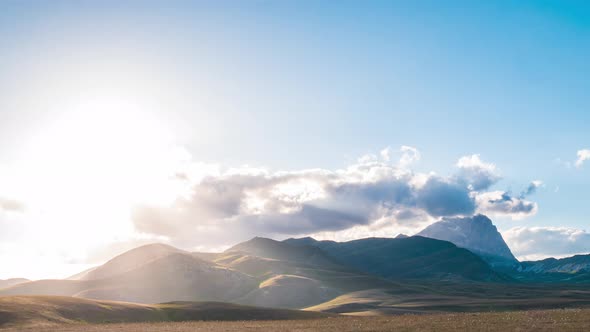 Time lapse: clouds moving in the sky, sunset view point over rocky mountains, highlands and pastures