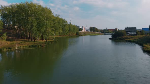 The Drone Flies Over the River of a Small Town on the Banks of the Dome of the Chrestian Church and