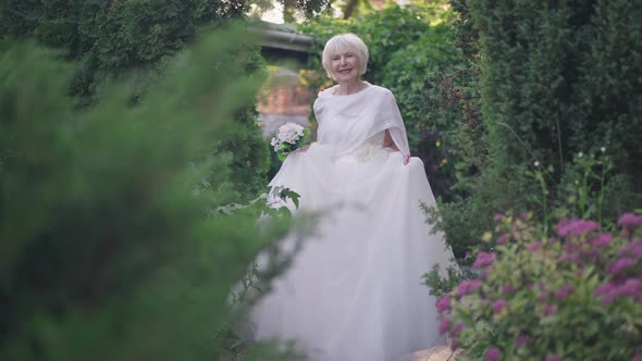 Front View Happy Senior Woman in Wedding Dress Walking to Camera in Slow Motion Smiling