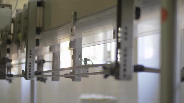 Empty Water Bottles on Factory Conveyor Belt. Rows of Empty Plastic Bottles at Bottling Plant on