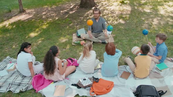 Group of Children Learning about Solar System in Park