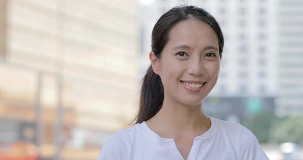 Woman smiling to the camera in the city 