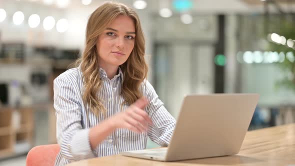 Appreciative Businesswoman with Laptop Doing Thumbs Up