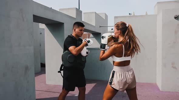 Boxing Training at the Construction Site  Young Woman in White Top Training Her Punches with a Coach