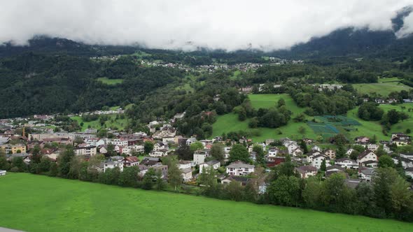 Liechtenstein with Houses on Green Fields in Alps Mountain Valley Aerial View