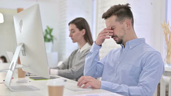 Tired Creative Male Professional Having Headache in Office