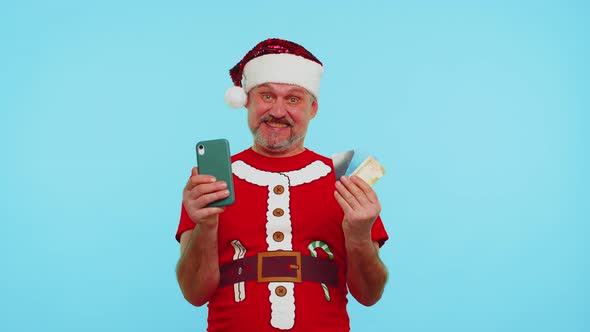 Man in Christmas Red Tshirt Use Mobile Cell Phone Plastic Credit Bank Cards Win Calebrate Wow