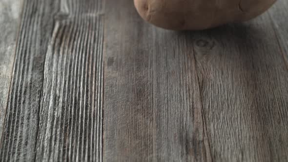 Potatoes falling and rolling on a table. Slow Motion.