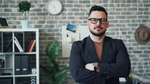 Portrait of Middle-aged Entrepreneur Standing in Office with Arms Crossed