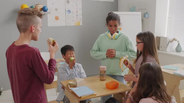 Happy Children Eating Lunch in Classroom and Laughing