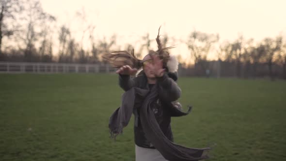 Attractive Young Hipster Woman in a Stylish Look Dancing Freestyle on Urban Background at Sunset or