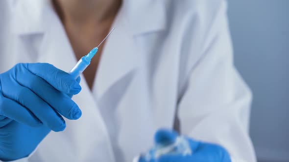 Female Nurse Preparing Injection Syringe, Filling With Ampoule Liquid, First Aid