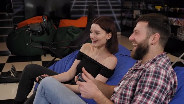 A Happy Young Couple are Playing Video Games in an Entertaining Game Room