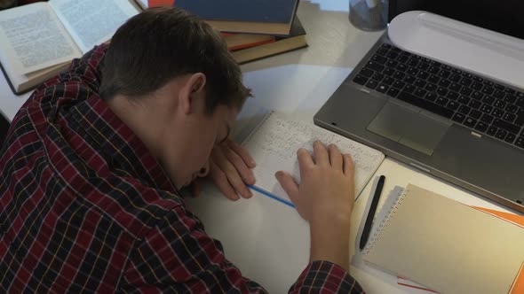 College student doing homework at night, sleeping on the table, tiredness