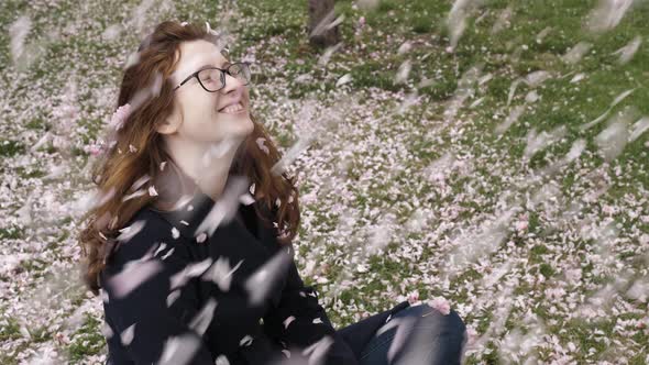 The Girl Blows Sakura Petals