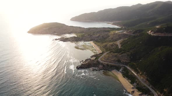 Seascape with beach and sunbeams reflecting in sea. Aerial backwards. Vietnam