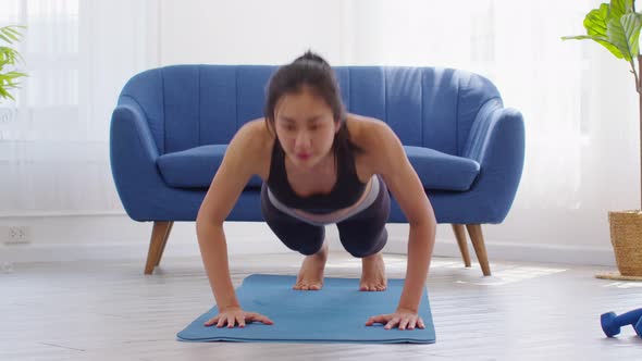 Asian girl doing push ups workout exercise on exercise mats concentration on shoulder muscle