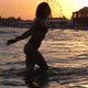 Jolly Brunette Girl in Bikini Throwing Water on River Bank in Slow Motion - VideoHive Item for Sale