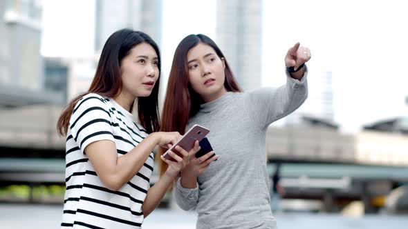 Two Teenager travellers checking location map on smartphone 