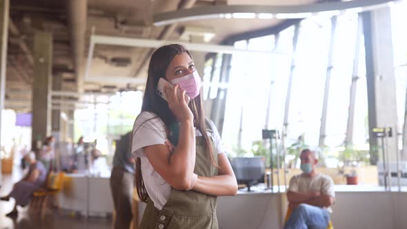 Young Woman in Pink Protective Medical Face Mask Talking on Mobile Phone at Indoor