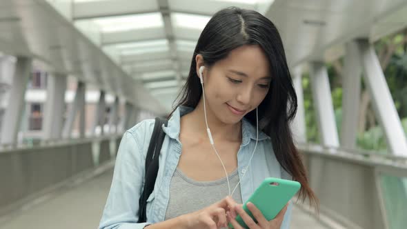 Woman listen to music on cellphone at outdoor