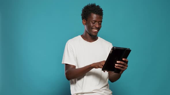 African American Man Using Digital Tablet and Smiling