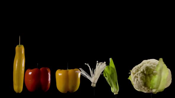 Array of colorful organic vegetables spin in fast motion on black background. Part of series. Meatle