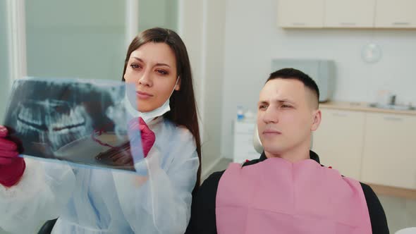 The Doctor Together with the Patient Examines the Xray of the Teeth in the Dental Clinic