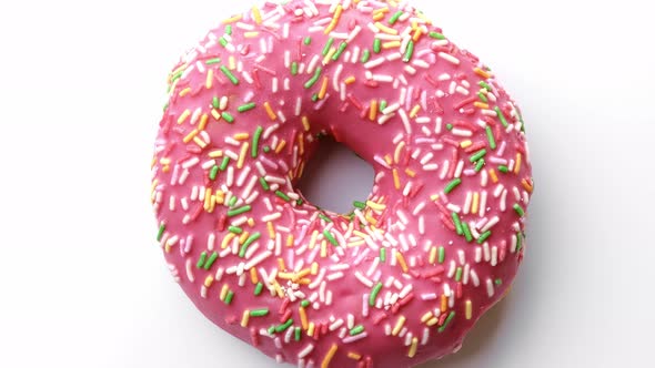 Closeup Pink Doughnut with Pastry Topping Rotating Isolated Top View