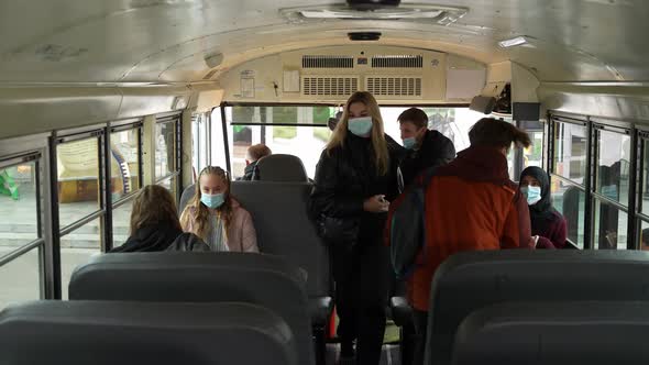 Multiracial Teens in Face Masks Entering Schoolbus