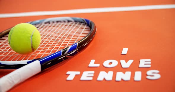 Tennis ball and racket with I love tennis text in court 4k