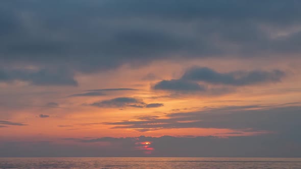 View of Sunset sun and clouds above sea.