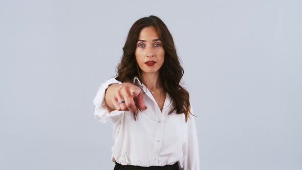 Brunette Girl in White Shirt is Smiling Pointing at you and Calling you By Her Forefinger While