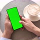 Man holding smartphone with vertical green screen and drinking coffee. - VideoHive Item for Sale