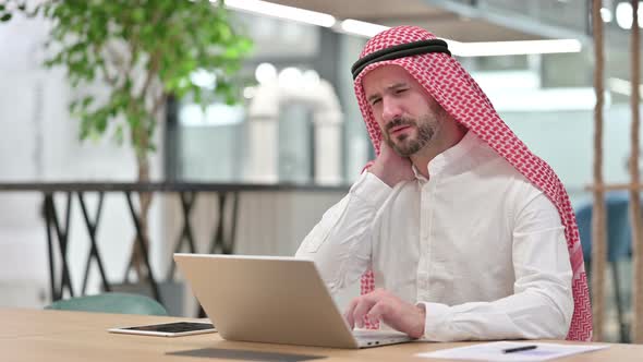 Tired Arab Businessman with Laptop Having Neck Pain 