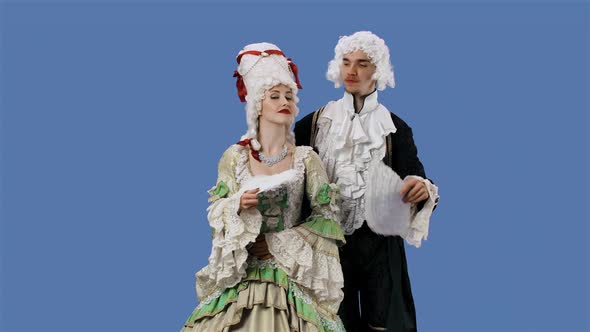 Portrait of Courtier Lady and Gentleman in Historical Vintage Costumes and Wig is Waving a Fan