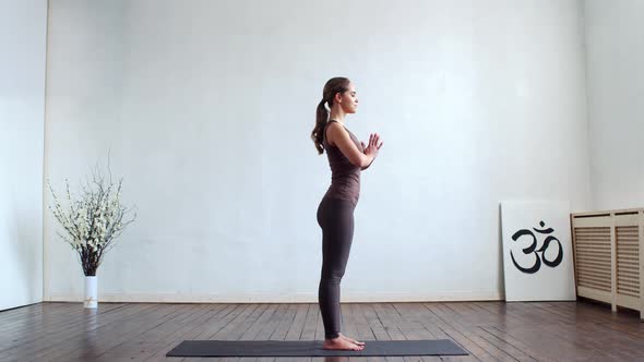 Young and fit woman practicing yoga indoor in the class.