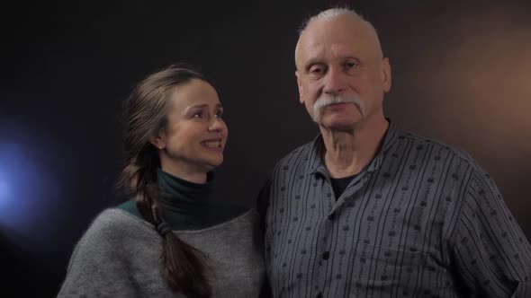 Woman Scratches Head Near Calming Aged Man and Raises Arms