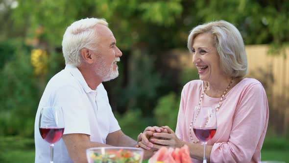 Senior Couple Laughing at Dining Table, Telling Funny Jokes, Remembering Moments