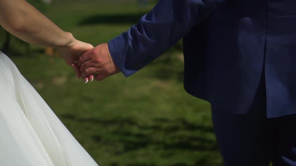 Brides Walk in the Park Holding Hands