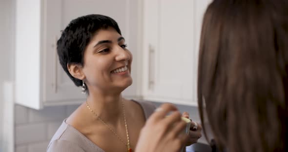 Happy girl friends lesbian couple enjoying a cup of tea or coffee in their ne