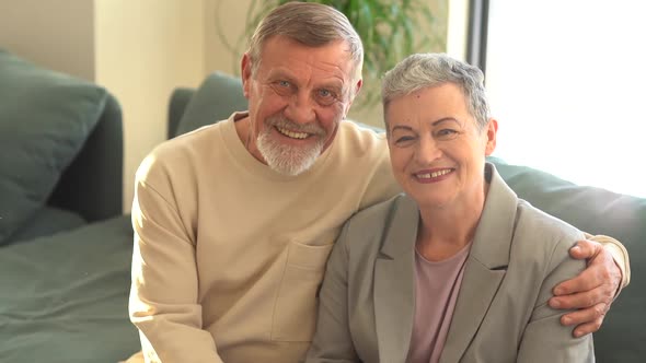 Close Portrait of Smiling Elderly Husband and Wife Looking at Camera